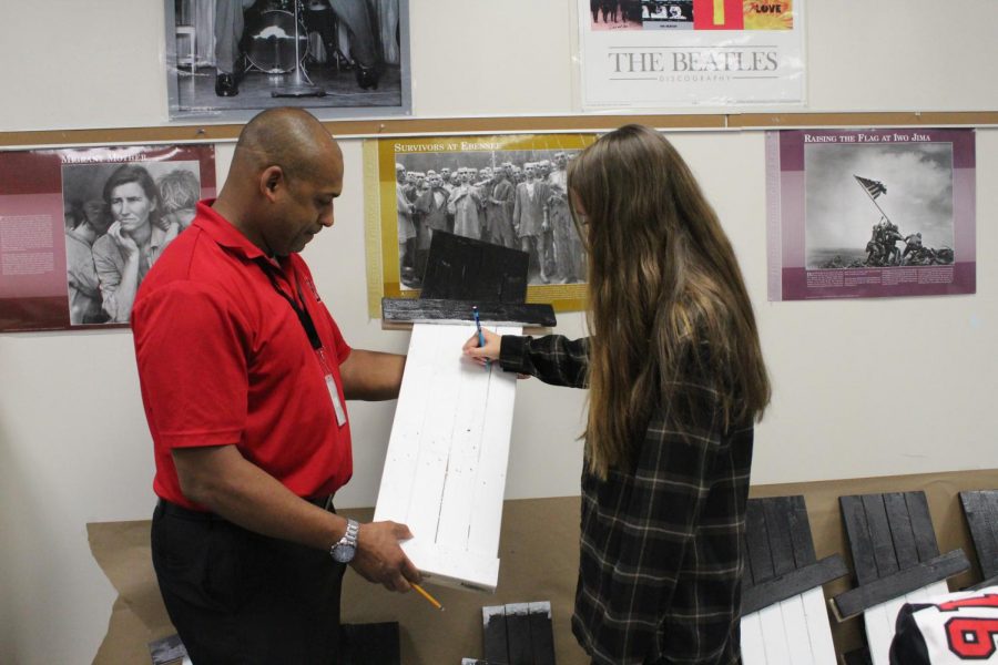Adviser Krisitian Ward helps a student work on a craft to be sold at the Craft Fair on Nov. 3