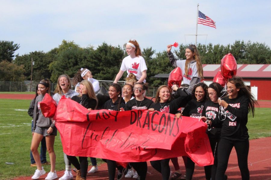 The girls field hockey team celebrates their successful season as they parade  down the track during the Homecoming pep rally.